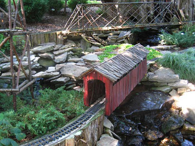 Red covered bridge made of rough pieces of wood