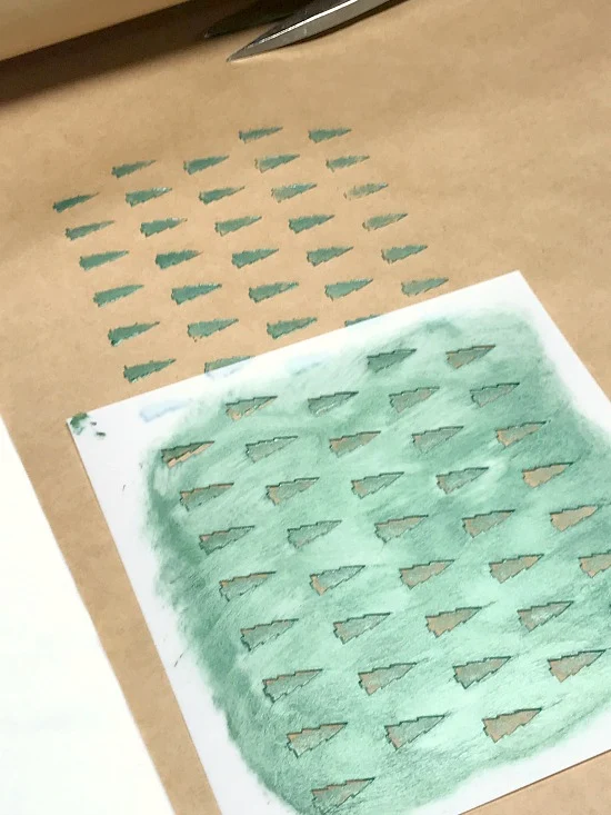 Stencil and green trees on brown paper