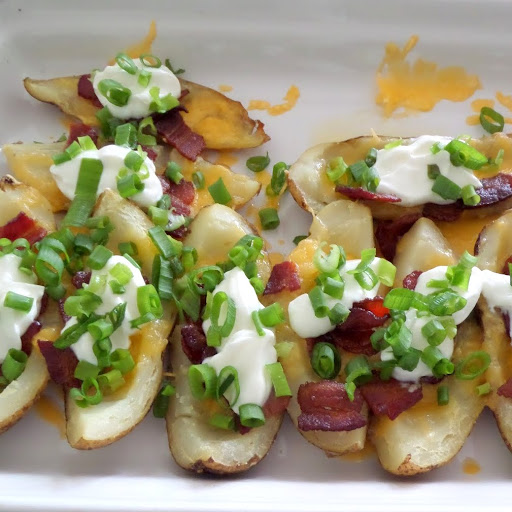 Loaded Baked Potato Skins:  Warm potato skins loaded with cheese, bacon, sour cream, and green onions.  A delicious gameday snack.  #footballsnack