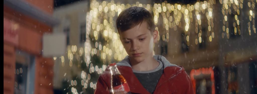 Pubblicità Coca Cola con il bambino che regala la bibita per il Natale 2016: ragazza e modella spot