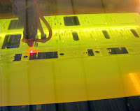 laser cutting the design, viewed through heavily tinted filter