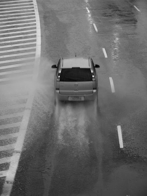 carro passa sobre um poça d'água