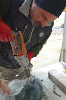 Quarryman Marco Nardini uses a diamond drill to core a hole in marble.