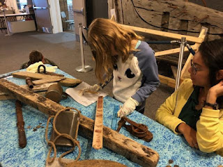 Two students next to debris field table ruler and worksheet, one student is wearing latex gloves Two students next to debris field table ruler and worksheet, one student is wearing latex gloves