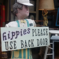 Sign that reads "hippies please use the back door"