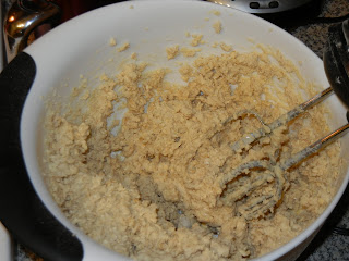 beating cookie dough together in a white bowl with a hand mixer 