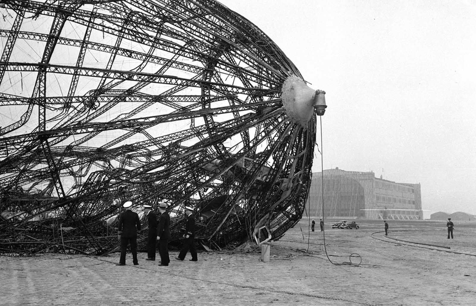 Members of the U.S. Navy Board of Inquiry inspect the wreckage of the German zeppelin Hindenburg on the field in New Jersey, on May 8, 1937.