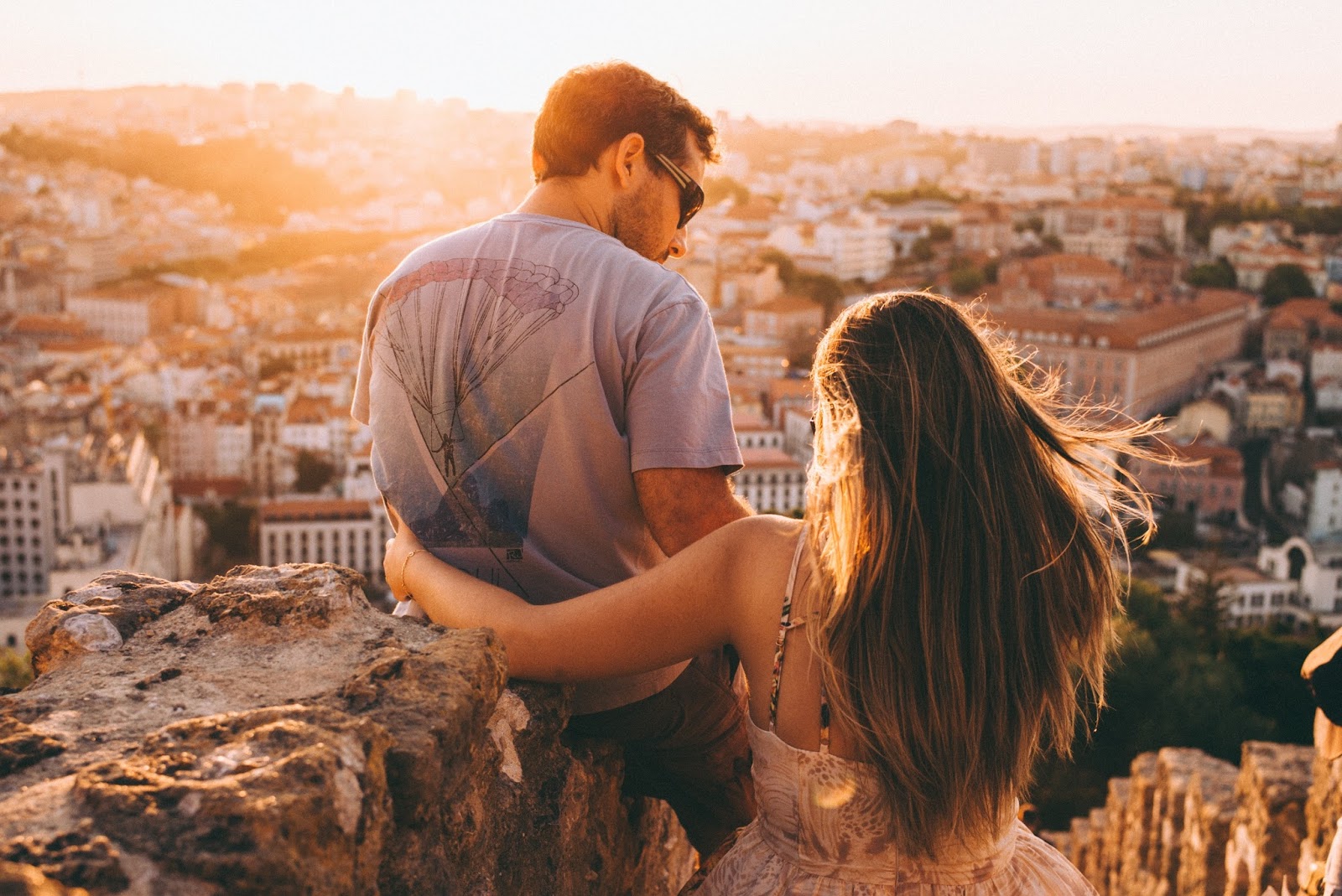 Man and woman gazing over a town below from a high vantage point