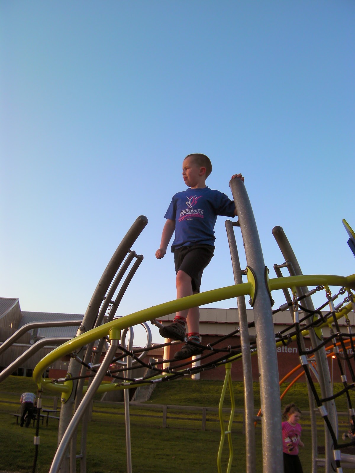 boy looks into setting sun from top of park climbing frame alexandra playpark northern parade portsmouth by mountbatten centre