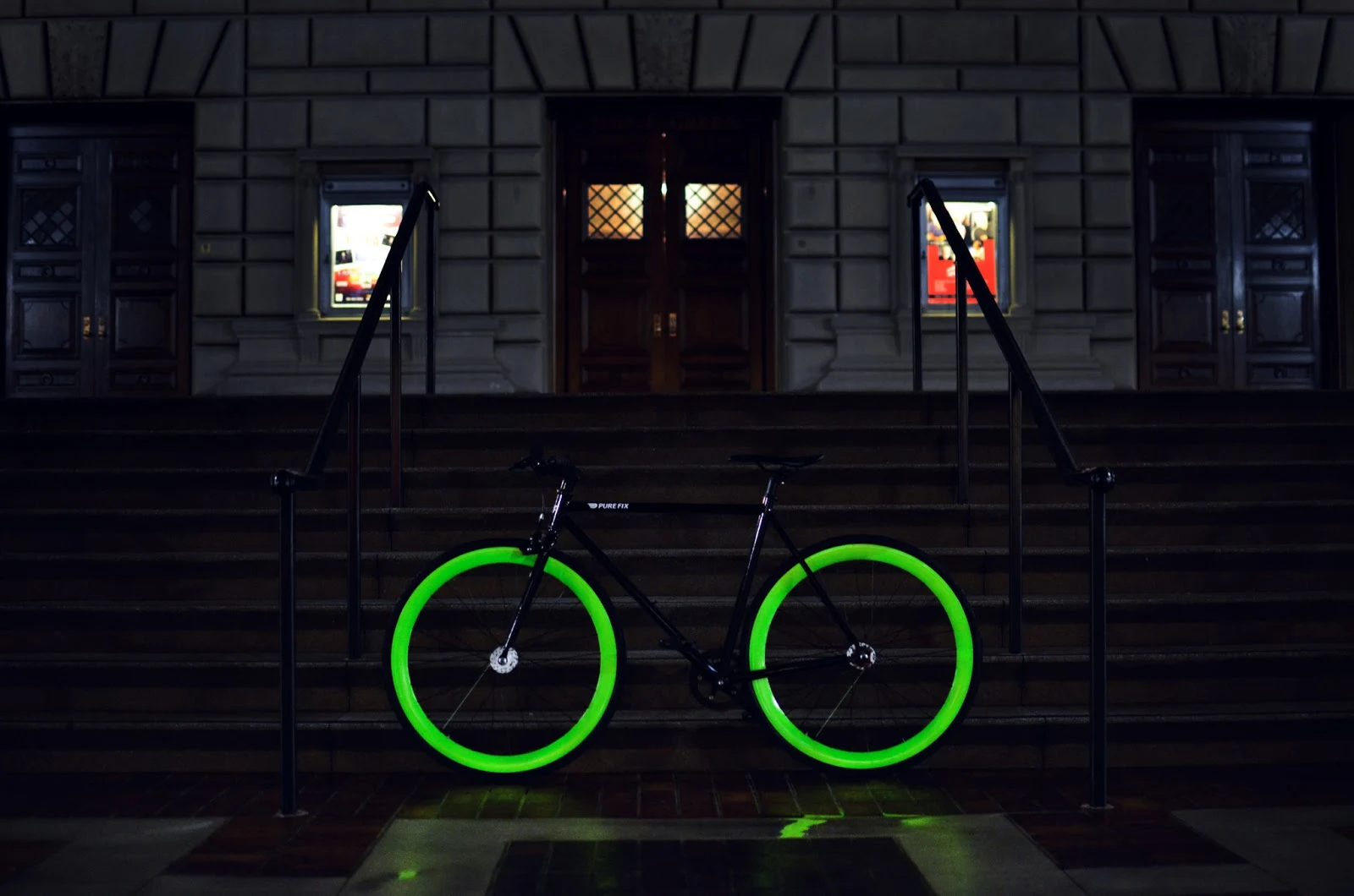 Ein Fahrrad mit leuchtenden Reifen steht vor einem Hotel