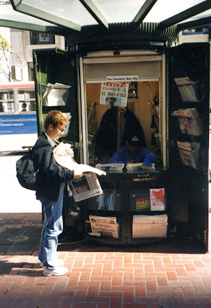 En un kiosco de periódicos tras los extras de la prensa.