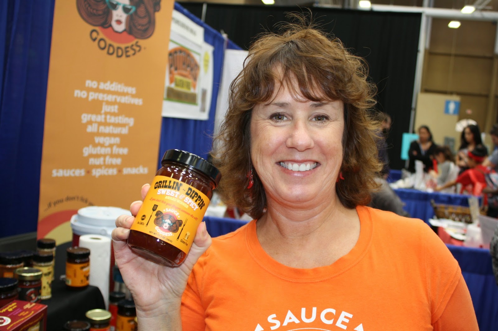 Jennifer, the Sauce Goddess, holding a jar of her bbq sauce