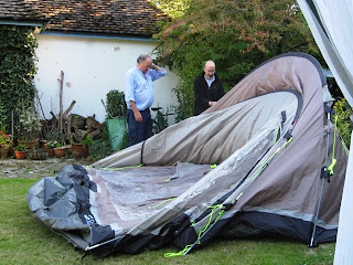 The tent appears to have collapsed. J has his hand to his head.