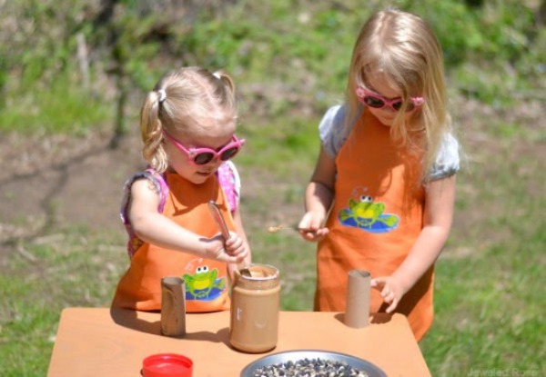 Make bird feeders using cardboard tubes and peanut butter!  These kid made bird feeders are the perfect craft for spring! #birdfeeders #birds #birdfeedersdiy #birdfeedersforkidstomake #birdfeedercraft #birdfeedershomemade #kidmadebirdfeeders #springcraftsforkids