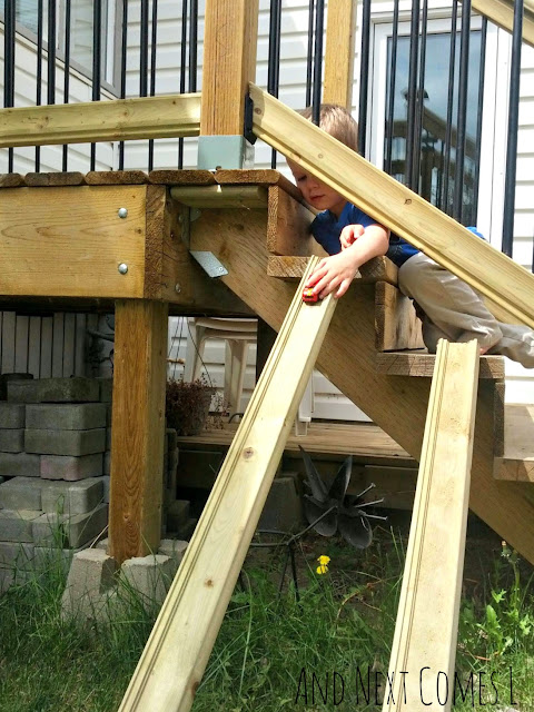 Child playing with car ramps for kids in the backyard