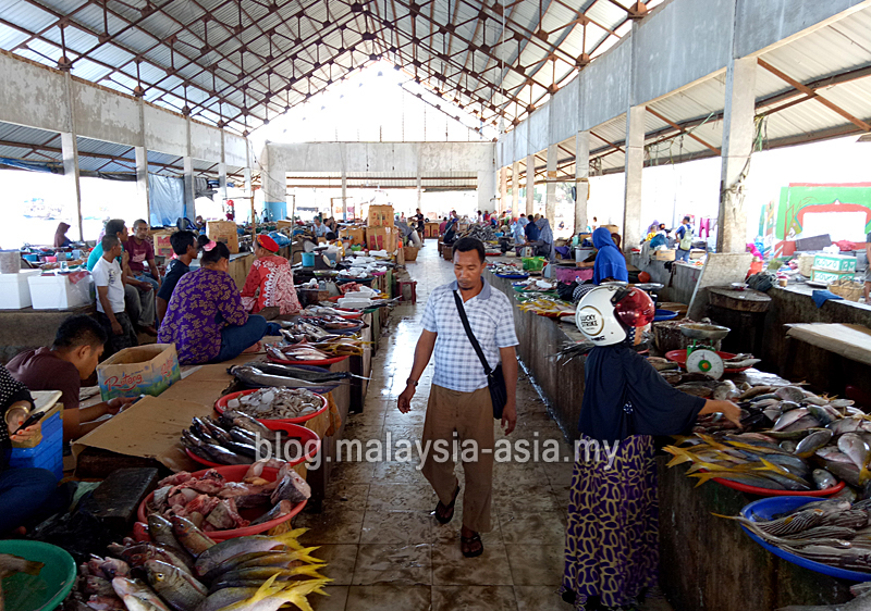 Local market vendor accepting cash payment in Labuan Bajo
