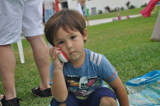 Beautiful brown eyed boy 2 years age holding phone loking bored and cute Beautiful brown eyed boy 2 years age holding phone loking bored and cute