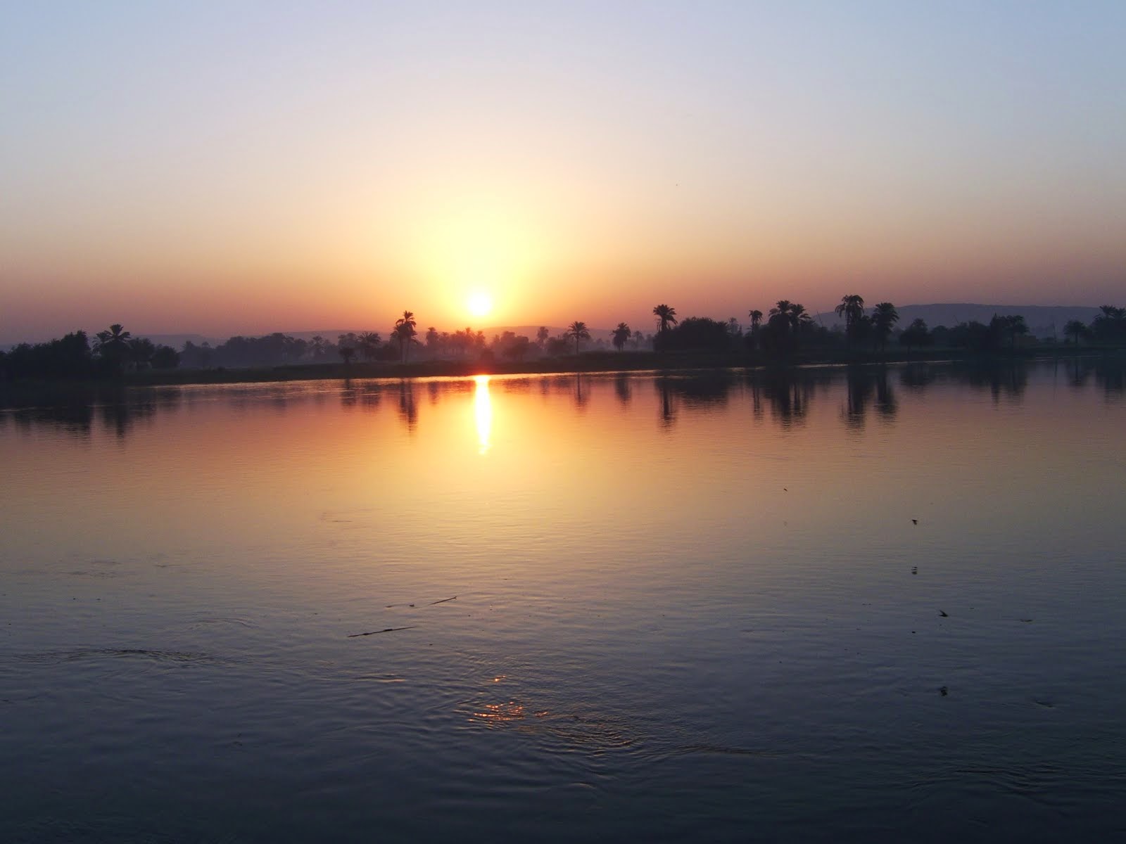 لحظة شروق الشمس على نهر النيل بمدينة ملوى