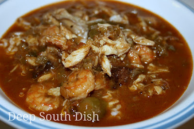 A seafood gumbo made with a dark roux, a rich shrimp stock, the Trinity of vegetables, tomatoes, andouille and shrimp, crab and oysters.