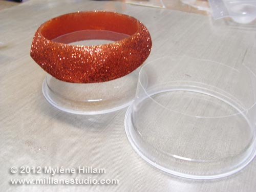 Glittered bangle supported on a cup ready for a coat of resin
