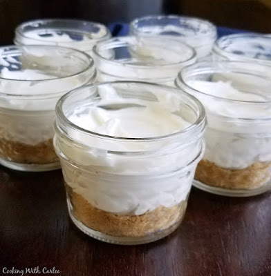 These little no bake lemon cheesecakes are served in an individual jar making them perfectly portable, giftable or hide-able if you want to keep them for yourself! The easy homemade blueberry topping is the perfect accompaniment to make them shine. small glass jars with graham cracker crust and no bake lemon cheesecake filling