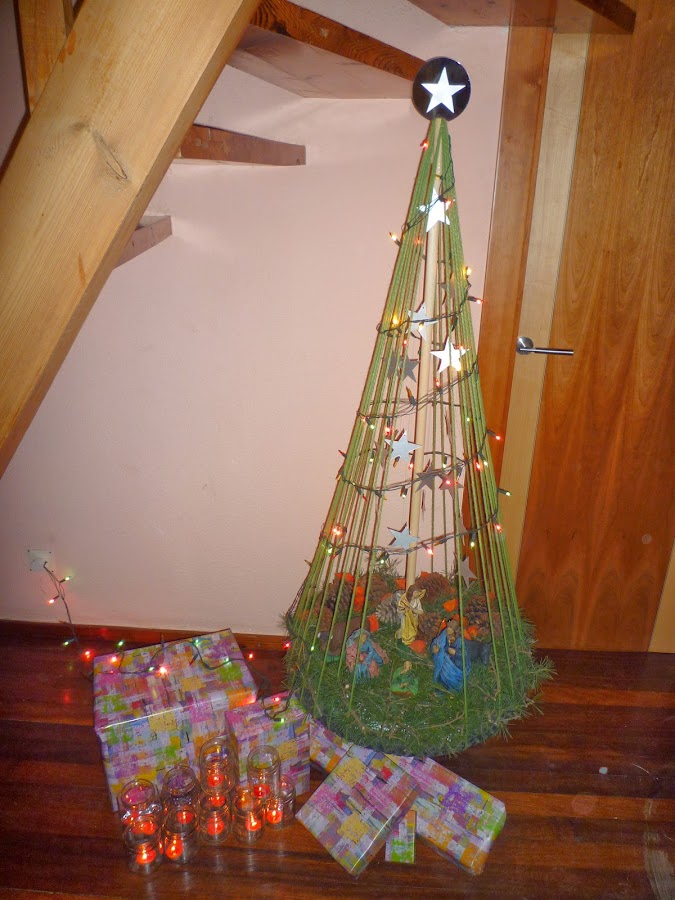 Árbol de Navidad y portal de Belén reciclado iluminado.