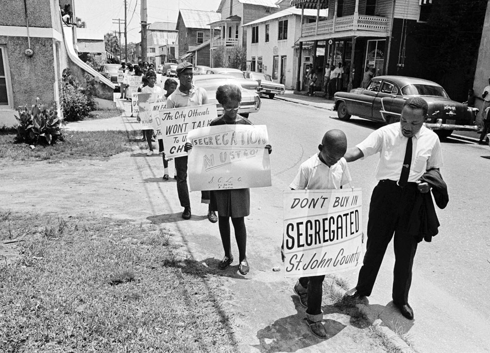 Dr. Martin Luther King, Jr. gives a young protester a pat on the back as a group of youngsters started to picket St. Augustine, Florida, on June 10, 1964.