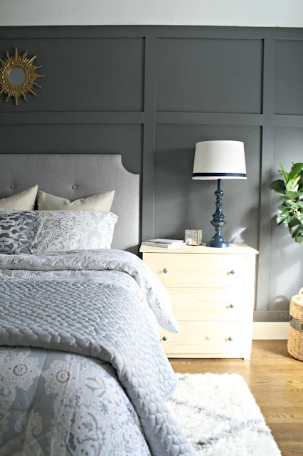 Dark paneled accent wall behind bed