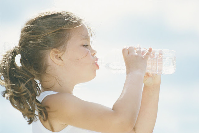 little girl holding a bottled water