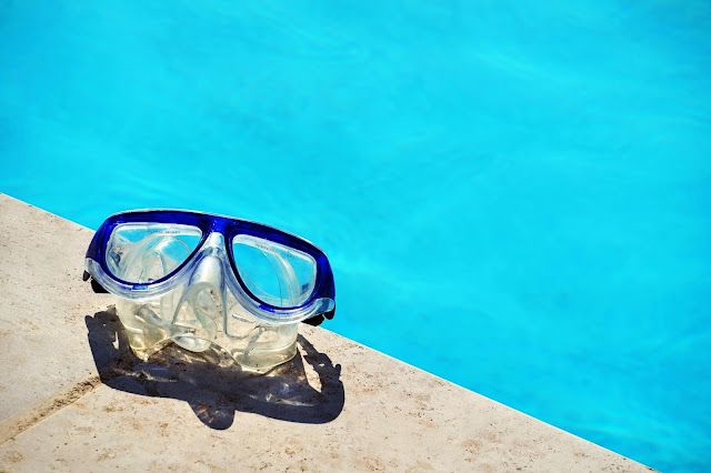 A snorkel mask next to a pool