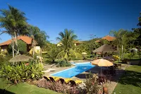 Piscina en jardín con cesped y palmeras del hotel Aguas de Bonito