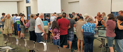 People examining sale items before aquarium society auction