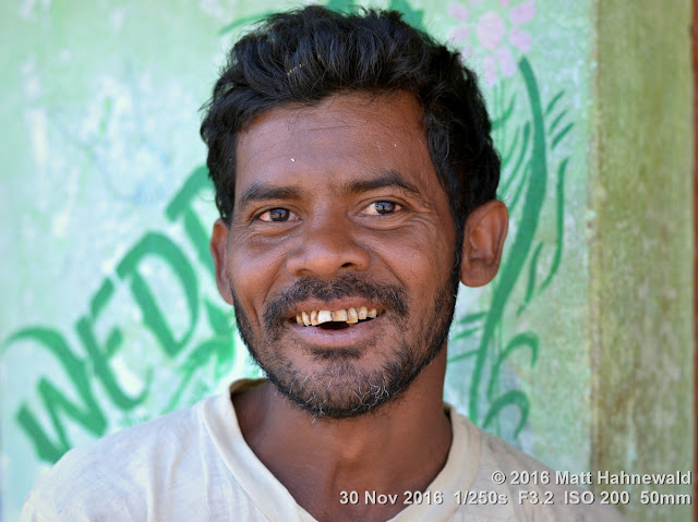 tribal; Adivasi; Christian; Matt Hahnewald Photography; Facing the World; photography; photo; image; face perception; physiognomy; psychological; educational; lively; favourite; superior; interesting; Nikon D3100; Nikkor AF-S 50mm f/1.8G; prime lens; 50mm lens; 4 : 3 aspect ratio; horizontal format; street; portraiture; portrait; closeup; headshot; seven-eighths view; brown; outdoor; colour; cultural; character; personality; real people; human head; human face; human eyes; nose; mouth; teeth; facial expression; eye contact; beard; bareheaded; consent; empathy; rapport; respect; encounter; relationship; emotion; fun; ethnic portrait; Kuvi Kondh tribe; Upper Bombu; Orissa; East India; modern Adivasi; one person; male; young adult; posing; smiling; handsome; happy; cheerful; manly; villager