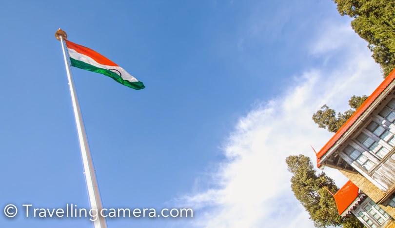 In the month of march, we visited this beautiful hill station in Himachal – Dalhousie. During the visit we stayed in Rashmi Villa which is clearly visible from surrounding hills of Dalhousie. When you are driving from Pathankot, you start seeing this place when you are 20 kilometers away from Dalhousie town. The huge flag installed in front of it an indicator. It’s a beautifully located place around Dalhousie hills and near to famous Dalhousie Public School. This Photo Journey shares some of the views we experienced during our 3 days stay at Rashmi Villa.Here is the photograph of flag installed at Rashmi Villa. Dalhousie came in national news because of this flag. Dalhousie Public school also has a MIG-21 and soon they will be having a battle tank T-54.There is a nice ground around this flag and kids love playing around it. Rashmi Villa is a very old building in the campus of Dalhousie Public School and maintained by school authorities.It was continuously raining when we were in Dalhousie and we really enjoyed the hide-n-seek of clouds around us. Many times these clouds visited us at Rashmi Villa to welcome in Dalhousie.  Just on the left hand side, there are multiple layers of hills. These hills were having snow where we visited Dalhouise. More than snow, I really liked these beautiful houses having similar architecture and aligned symmetrically on this mountain. We were wondering about the people living on this hill. They must be getting far better views of surrounding and probably they would have an opportunity to look at other side of the hill from top. Khajjiar, Chamba and Bharmour are on the other side this hill. These portions are not visible from Rashmi Villa. Rashmi Villa is facing towards hills leading towards Pathankot and Ravi riverYou can see numerous villages on surrounding hills and I love these roofs of Himachali houses. Most of these houses have vibrant and multicolored shades in a unique way.Rashmi Villa is mainly surrounded by hills which have various sub-campuses of Dalhousie Public School. The MIG-21 is directly visible on the right side and river Ravi offers various shades during different time of the day. Dalhousie had got snowfall a week back, when we visited the town. There were some remains of the snow around Rashmi Villa as well. But most of the surrounding hills were white. Pir Pnajal mountain range in above photograph looks amazing. And the view of these hills from Gandhi Chowk is brilliant.The view of Ravi River from Rashmi Villa is my favorite. Every morning and evening I used to stand near the national flag to experience the colors of Ravi River. I wanted to see the river during sunset or sunrise, but hazy weather didn’t allow me to even see the river during that time. I am sure that river must be looking stunning during clear days. Hope to be there soon and enjoy those brilliant landscapes again.