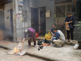 family burning paper replicas of items during Qingming