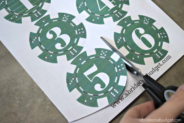 Planning a lucky in love themed wedding? Or maybe just love gambling? Put together these lucky in love lotto ticket centerpieces, plus get a free printable for the poker chip table numbers from www.abrideonabudget.com.