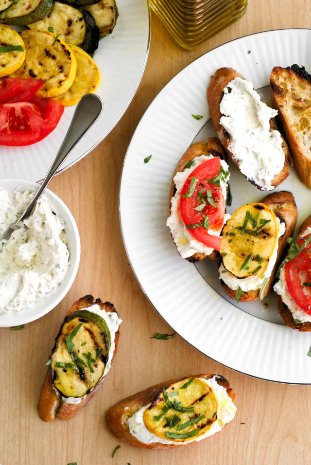 This Grilled Summer Squash and Tomato Crostini is the perfect summer appetizer featuring garden-fresh summer squash, tomatoes, and a Parmesan-herb cream cheese layered on a garlic toasted baguette.