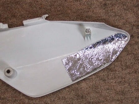 サイドカバーの内側(マフラーと接触する部分)には
キタコで販売されているシリコンシートが貼ってあります。 キタコ シリコンシートを貼付けたXR100モタードのサイドカバー