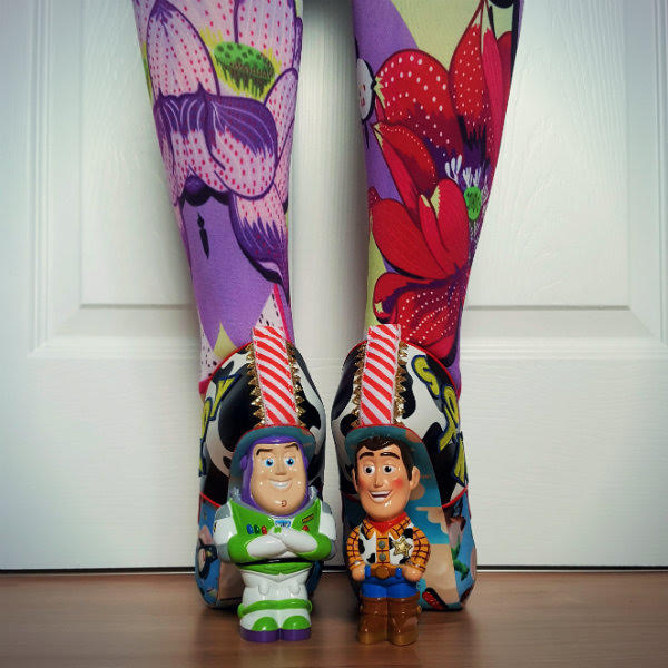 Irregular Choice You've Got A Friend In Me heels back view of legs in floral tights with Buzz and Woody Disney Toy Story character heels