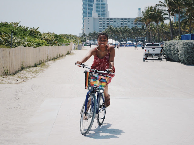 Miss Lauren Alston bicycling in the beach in a Madewell dress