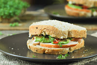 Sandwich de pollo ahumado, aguacate y tomates en aceite