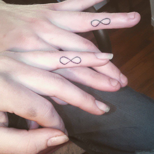 Vemos un tatuaje en pareja del símbolo de infinito en los dedos