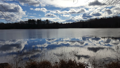 sun and clouds reflecting upon the lower pond at DelCarte