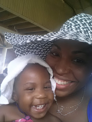 Mommy and toddler girl smiling into the camera wearing sun hats