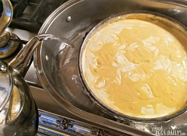 adding water to roasting pan under cheesecake