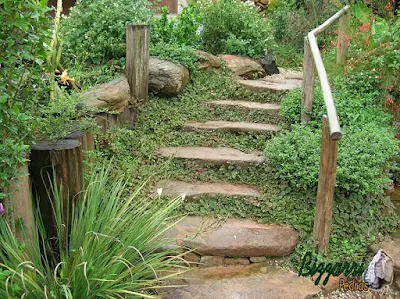 Pedra moledo para escada de pedra no jardim com pedras isoladas com junta de grama.
