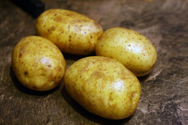 Four potatoes just washed and ready to be turned into oven baked fries.