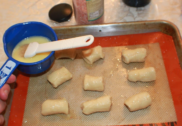 this is a photo of pretzel bites being brushed with egg. Delicious soft pretzel bites that have been brushed with butter, garlic and herbs baked and so easy to make