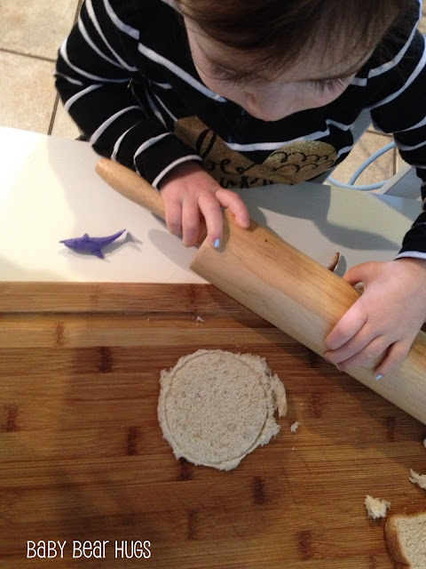 little girl rolling dough with a rolling pin