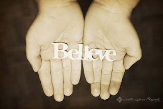 The word believe laid out in the palms of hands